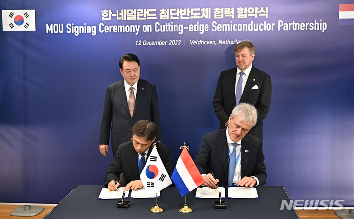 [벨트호벤=뉴시스] 조수정 기자 = 네덜란드를 국빈 방문한 윤석열 대통령과 빌럼 알렉산더르 국왕이 배석한 가운데 12일(현지시간) 벨트호벤 반도체장비 생산기업 기업인 ASML 본사에서 열린 SK하이닉스와 ASML간 극자외선 노광장비(EUV) 저전력 친환경 활용 기술협력 협약(MOU) 체결식에서 곽노정 SK하이닉스 사장과 피터 베닝크 ASML 회장이 서명을 하고 있다. 2023.12.12. chocrystal@newsis.com