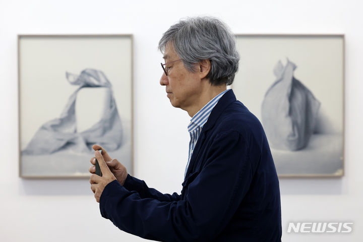 [서울=뉴시스] 박진희 기자 = 사진작가 구본창이 13일 서울 중구 서울시립미술관 서소문본관에서 열린 개인전 '구본창의 항해' 언론공개회에 참석하여 전시장 풍경을 사진 촬영하고 있다. 2023.12.13. pak7130@newsis.com