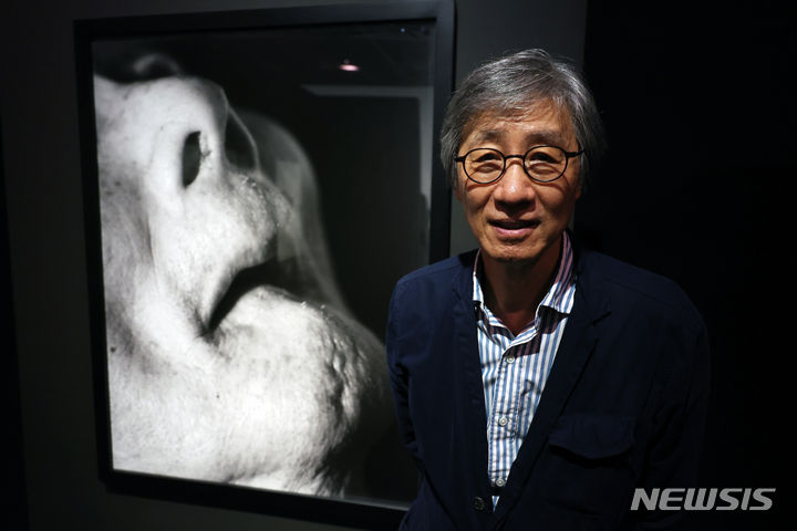 [서울=뉴시스] 박진희 기자 = 사진작가 구본창이 13일 서울 중구 서울시립미술관 서소문본관에서 열린 개인전 '구본창의 항해' 언론공개회에 참석하여 부친 모습을 담은 작품 앞에서 사진촬영을 하고 있다. 2023.12.13. pak7130@newsis.com