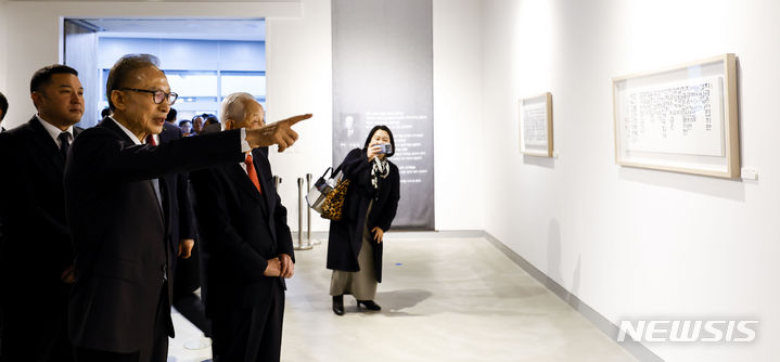 [서울=뉴시스] 정병혁 기자 = 이명박 전 대통령이 13일 서울 서초구 한전아트센터 갤러리에서 열린 첫 서예전 '스며들다' 개막식에 앞서 자신의 작품을 설명하고 있다. 2023.12.13. jhope@newsis.com