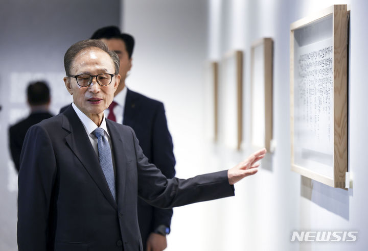 [서울=뉴시스] 정병혁 기자 = 이명박 전 대통령이 13일 서울 서초구 한전아트센터 갤러리에서 열린 첫 서예전 '스며들다' 개막식에 앞서 자신의 작품을 바라보고 있다. 2023.12.13. jhope@newsis.com