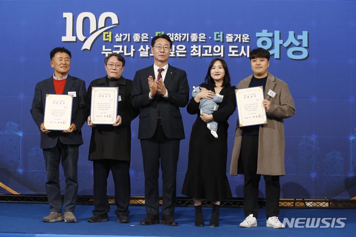 [화성=뉴시스] 정명근 화성시장(사진 왼쪽 세번째)이 14일 100만번째 화성시민 이광재 씨(왼쪽 두번째), 100만 30번째 화성시민 송명철 씨(왼쪽 첫번째), 100만 둥이 가족과 기념촬영을 하고 있다.(사진=화성시 제공) 2023.12.14.sonanom@newsis.com