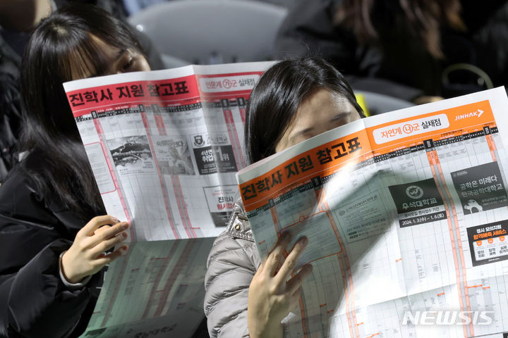 [서울=뉴시스] 조성우 기자 = 지난해 12월14일 오후 서울 송파구 잠실학생체육관에서 열린 진학사 2024학년도 정시 합격전략 설명회에서 수험생들이 지원 참고표를 보는 모습. 2024.01.06. xconfind@newsis.com