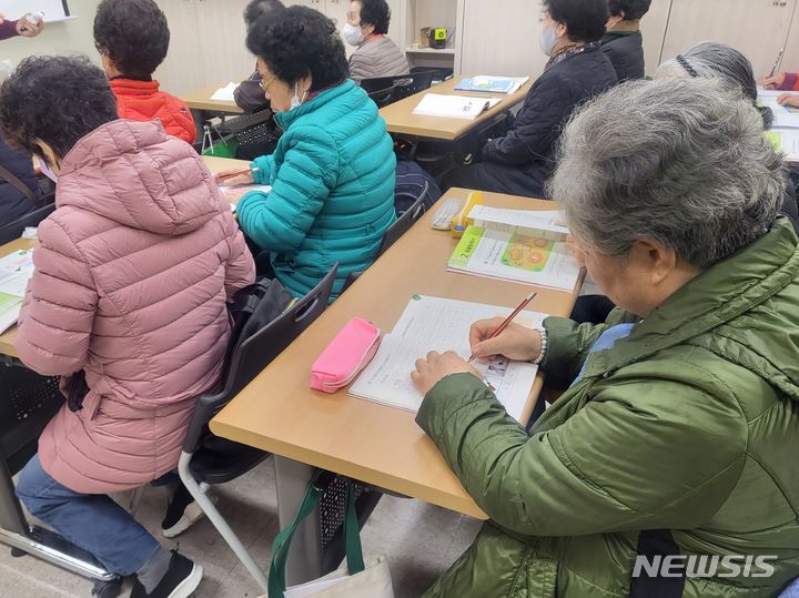 [부산=뉴시스] 김민지 기자 = 14일 오전 부산 남구 용호3동 마을건강센터에서 한글 수업이 진행되고 있다. 한글 필기에 열중인 한 주민의 모습. 2023.12.14. mingya@newsis.com