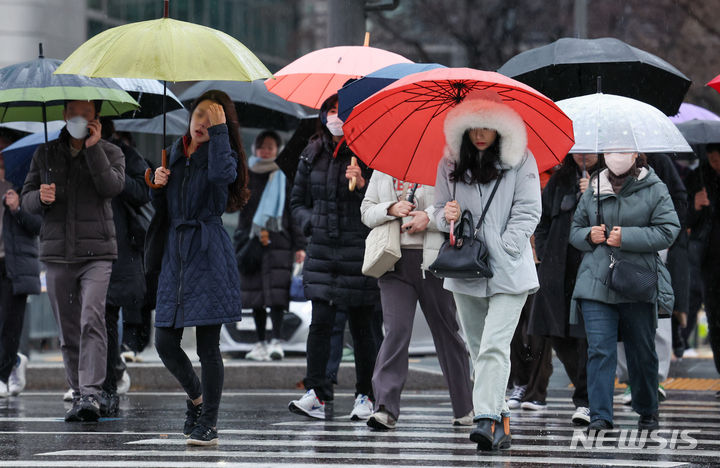 [서울=뉴시스] 황준선 기자 = 15일 오전 서울 종로구 세종대로 사거리에서 우산을 쓴 시민들이 발걸음을 재촉하고 있는 모습. 2023.12.15. hwang@newsis.com