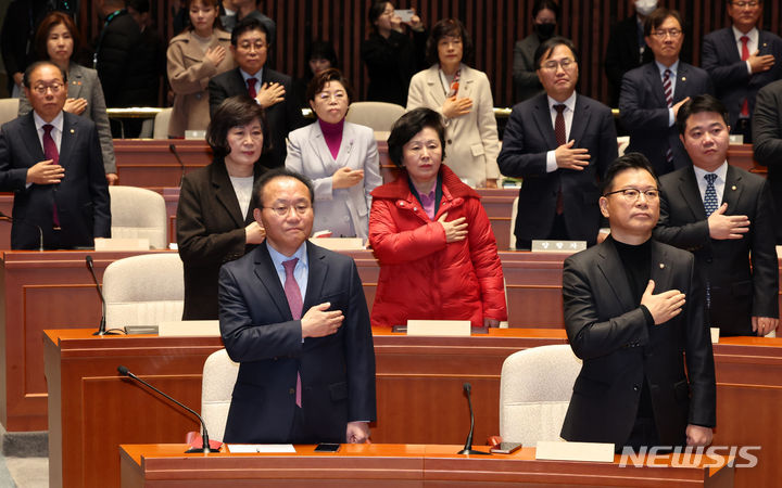 [서울=뉴시스] 이영환 기자 = 윤재옥 국민의힘 당 대표 권한대행 겸 원내대표와 이양수 원내수석부대표 등 의원들이 15일 오전 서울 여의도 국회에서 열린 비상의원총회에서 국민의례를 하고 있다. 2023.12.15. 20hwan@newsis.com