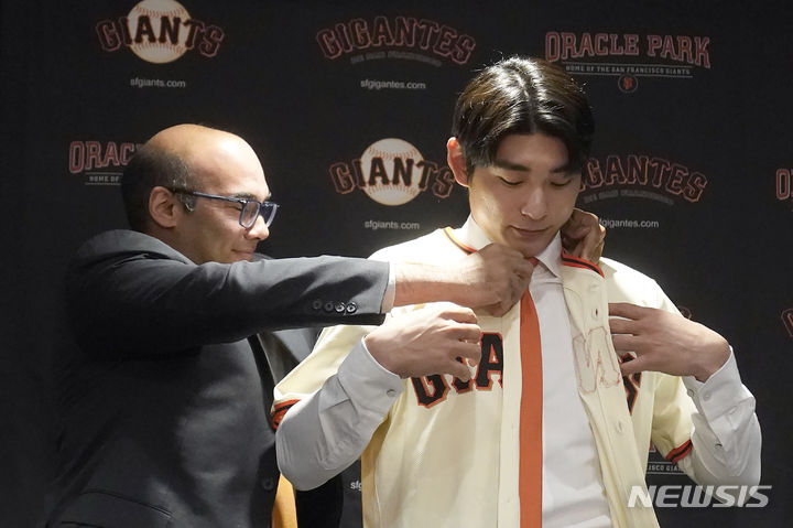 [샌프란시스코=AP/뉴시스]이정후(오른쪽)가 샌프란시스코 자이언츠 입단식에서 유니폼을 입고 있다. 2023.12.16.