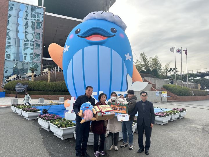 [울산=뉴시스]지난16일 울산 남구도시관리공단 이춘실 이사장(오른쪽 첫번째)이 올해 장생포 고래문화특구 130만번째 방문 가족에게 기념품을 전달한 뒤 함께 기념촬영을 하고 있다. (사진=울산 남구도시관리공단 제공) photo@newsis.com *재판매 및 DB 금지