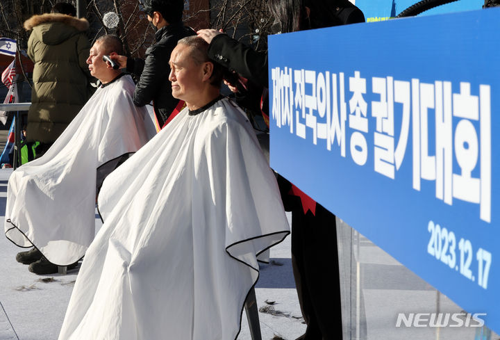 [서울=뉴시스] 배훈식 기자 = 이정근(왼쪽) 대한의사협회 상근 부회장과 김광채 광주 서구의사회 회장이 17일 오후 서울 종로구 동화면세점 앞에서 열린 '의료붕괴 저지를 위한 '제1차 전국 의사 총궐기 대회'에 참석해 의과대학 정원 정책 폐기를 촉구하며 삭발하고 있다. 2023.12.17. dahora83@newsis.com