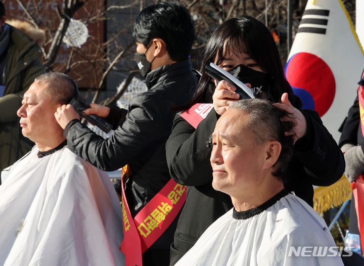 [서울=뉴시스] 배훈식 기자 = 이정근(왼쪽) 대한의사협회 상근 부회장과 김광채 광주 서구의사회 회장이 17일 오후 서울 종로구 동화면세점 앞에서 열린 '의료붕괴 저지를 위한 '제1차 전국 의사 총궐기 대회'에 참석해 의과대학 정원 정책 폐기를 촉구하며 삭발하고 있다. 2023.12.17. dahora83@newsis.com