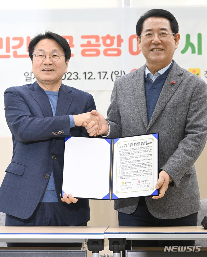 [나주=뉴시스] 이영주 기자 = 강기정 광주시장(왼쪽)과 김영록 전남도지사가 17일 오후 전남 나주 한국농수산식품유통공사 1층 로비에서 광주 군·민간 공항 이전 시·도지사 회담을 마친 뒤 발표문을 든 채 악수하고 있다. 2023.12.17. leeyj2578@newsis.com