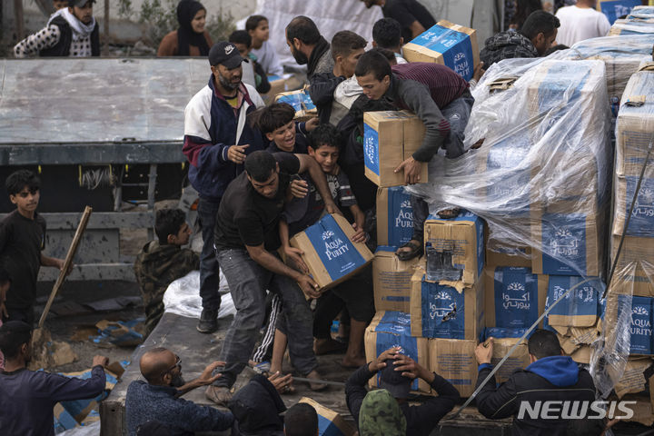 [라파=AP/뉴시스] 17일(현지시각) 가자지구 라파에서 팔레스타인 난민들이 인도주의적 구호 물품을 실은 트럭을 약탈하고 있다. 2023.12.18.