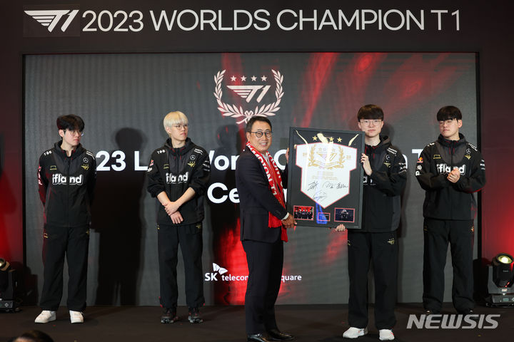 [서울=뉴시스] 김근수 기자 = T1 소속 '페이커' 이상혁이 18일 서울 중구 을지로 SK텔레콤 본사 사옥에서 열린 SK텔레콤-SK 스퀘어 임직원과 함께하는 T1 롤드컵 축하행사에서 유영상 SK텔레콤 대표이사에게 T1 선수단 기념액자를 전달하고 있다. 2023.12.18. ks@newsis.com