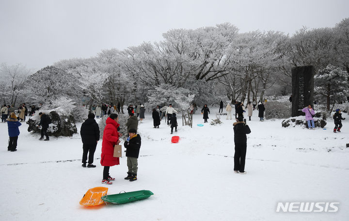 [제주=뉴시스] 우장호 기자 = 주말동안 많은 눈이 내린 가운데 18일 오후 제주 한라산 1100도로 휴게소를 찾은 방문객들이 설경을 감상하며 즐거운 시간을 보내고 있다. 기상청에 따르면 오는 20일부터 이른바 '북극 한파'가 찾아와 올겨울 들어 가장 강력한 추위가 극성을 부릴 것으로 예보됐다. 2023.12.18. woo1223@newsis.com