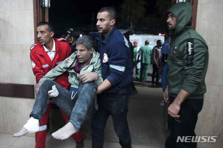 [가자지구=AP/뉴시스] 19일(현지시각) 가자지구 데이르 알발라에서 이스라엘의 폭격으로 다친 팔레스타인 주민이 사람들의 도움을 받으며 병원으로 들어서고 있다. 2023.12.20.