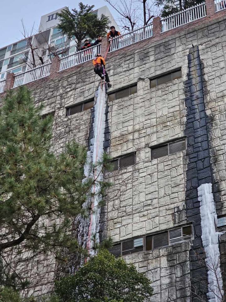 [부산=뉴시스] 원동화 기자 = 부산소방재난본부는 19일 해운대구 한 아파트 옹벽에 60m 고드름을 제거했다. (사진=부산소방재난본부 제공) 2023.12.20. photo@newsis.com *재판매 및 DB 금지