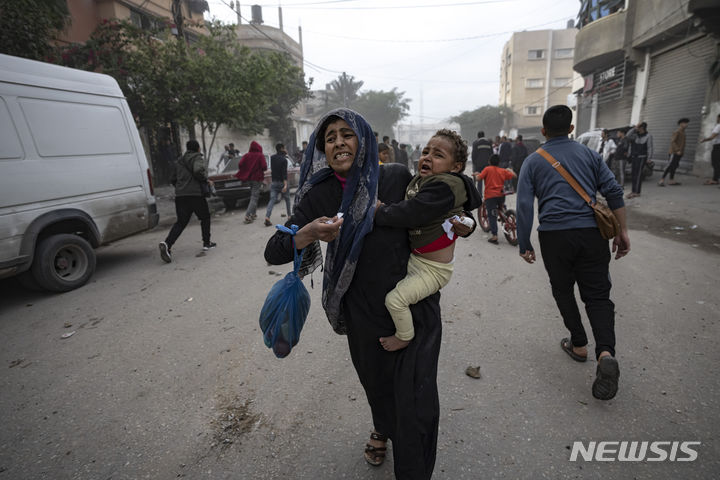 [라파=AP/뉴시스] 20일(현지시각) 가자지구 남부 라파 팔레스타인 주민들이 이스라엘의 폭격 피해 지역을 다급히 벗어나고 있다. 2023.12.21.