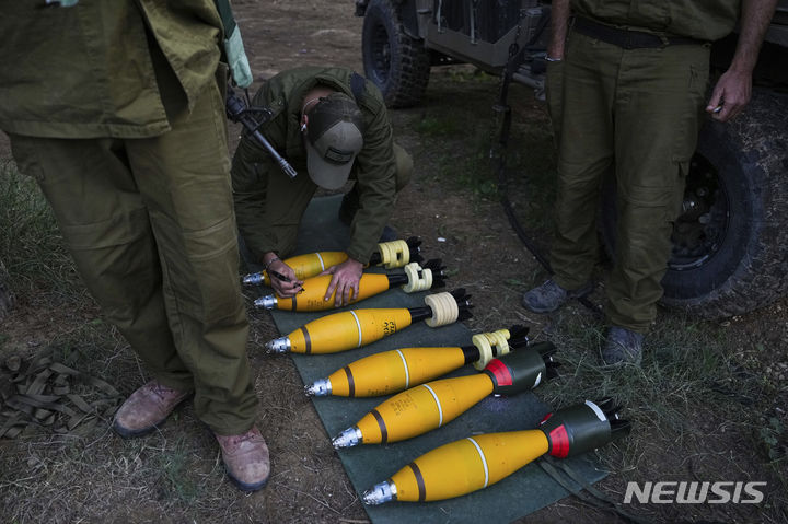 [가자지구=AP/뉴시스] 20일(현지시각) 이스라엘 남부, 가자지구 인근 진지에서 한 이스라엘 군인이 박격포탄에 무언가를 쓰고 있다. 2023.12.21.