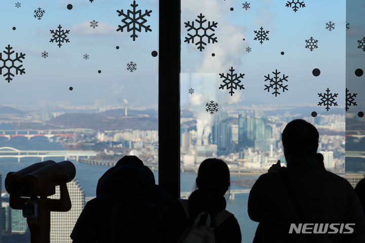 [서울=뉴시스] 권창회 기자 = 서울을 비롯한 내륙 대부분 한파특보가 발효된 21일 오전 서울 여의도 63스퀘어 전망대에서 시민들이 도심을 구경하고 있다. 2023.12.21. kch0523@newsis.com