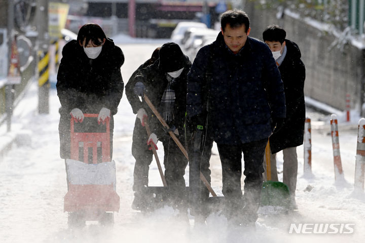 [광주=뉴시스] 이영주 기자 = 광주 지역에 밤사이 많은 눈이 내린 21일 오전 광주 북구 운암동 한 이면도로에서 운암3동 행정복지센터 직원들이 제설 작업을 하고 있다. 2023.12.21. leeyj2578@newsis.com