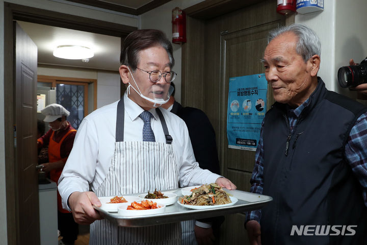 [서울=뉴시스] 국회사진기자단 = 이재명 더불어민주당 대표가 21일 오전 서울 영등포구 구립 큰숲 경로당에서 어르신들에게 배식 봉사를 하고 있다. 이 대표는 식사를 마친 후 주5일 점심 제공 정책 간담회에 참석했다. 2023.12.21. photo@newsis.com