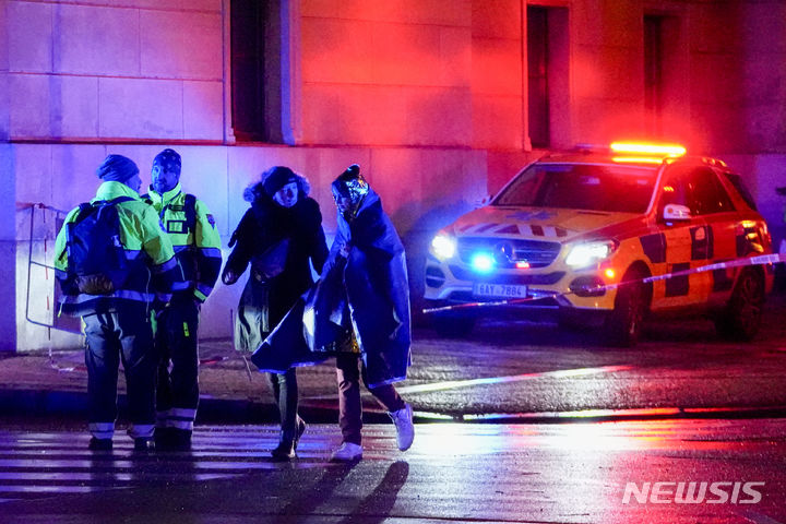 [프라하=AP/뉴시스] 21일(현지시간) 체코 프라하 카렐대학교 철학과 건물 인근에서 시민들이 온열 담요를 두른 채 이동하고 있다. 체코 경찰에 따르면 이 학교에서 대규모 총격이 발생해 15명이 숨지고 24명이 다쳤다. 2023.12.22.