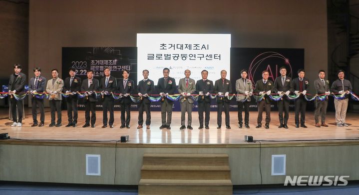 [창원=뉴시스]홍정명 기자=22일 경남대학교 한마관에서 열린 국내 최초 '초거대제조AI 글로벌 공동연구센터' 개소식에 참석한 주요 인사들이 기념 테이프를 자르고 있다.(사진=경남도 제공) 2023.12.22. photo@newsis.com