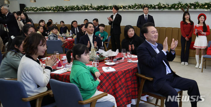 [서울=뉴시스] 조수정 기자 = 윤석열 대통령이 22일 서울 용산 대통령실 청사에서 열린 '히어로즈 패밀리와 함께하는 꿈과 희망의 크리스마스' 행사에서 순직 군인·경찰·소방관 유가족들과 브릴란떼 어린이합창단의 캐롤 메들리 공연을 관람하며 박수치고 있다. 2023.12.22. chocrystal@newsis.com