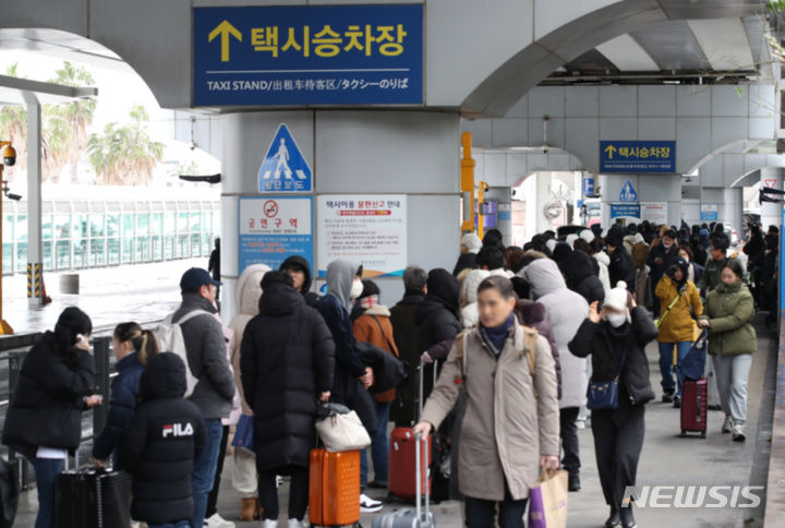 [제주=뉴시스] 우장호 기자 = 대설특보가 내려진 22일 오후 폭설로 인해 항공기 결항이 결정된 이용객들이 제주국제공항 빠져나와 택시를 기다리고 있다. 2023.12.22. woo1223@newsis.com