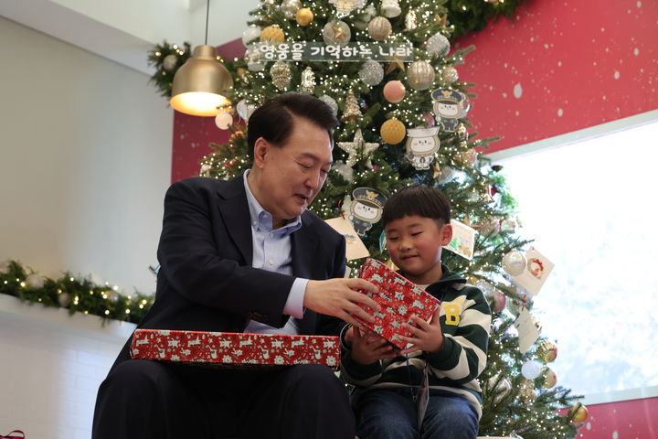 [서울=뉴시스] 윤석열 대통령이 22일 서울 용산 대통령실 청사에서 열린 '히어로즈 패밀리와 함께하는 꿈과 희망의 크리스마스' 행사에서 초청한 순직 군인·경찰·소방관 자녀들의 꿈을 듣고 격려하며 선물을 전달하고 있다. (사진=대통령실 제공) 2023.12.22. photo@newsis.com *재판매 및 DB 금지
