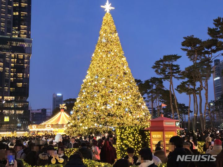 [서울=뉴시스] 이태성 기자 = 크리스마스이브인 24일 오후 18시께 서울 송파구 롯데월드타워 앞 일대는 크리스마스 장식을 구경하기 위해 찾은 인파로 인산인해를 이뤘다. 2023.12.24. victory@newsis.com *재판매 및 DB 금지