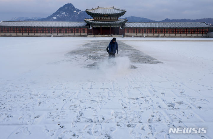 [서울=뉴시스] 정병혁 기자 = 크리스마스 이브인 24일 서울 종로구 경복궁에서 관계자가 밤에 내린 눈을 치우고 있다. 2023.12.24. jhope@newsis.com