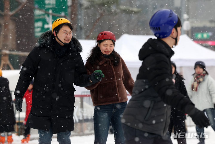 [서울=뉴시스] 김명년 기자 = 크리스마스인 25일 오전 서울 중구 서울광장 스케이트장에서 시민들이 눈을 맞으며 스케이트를 타고 있다. 2023.12.25. kmn@newsis.com