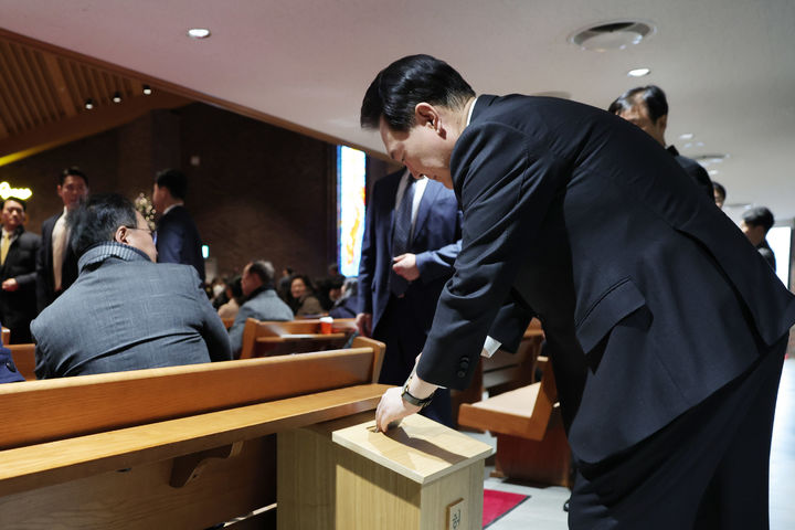 [서울=뉴시스] 윤석열 대통령이 25일 서울 중구 정동제일교회에서 열린 성탄 예배에 참석해 헌금하고 있다. (사진=대통령실 제공) 2023.12.25. photo@newsis.com *재판매 및 DB 금지
