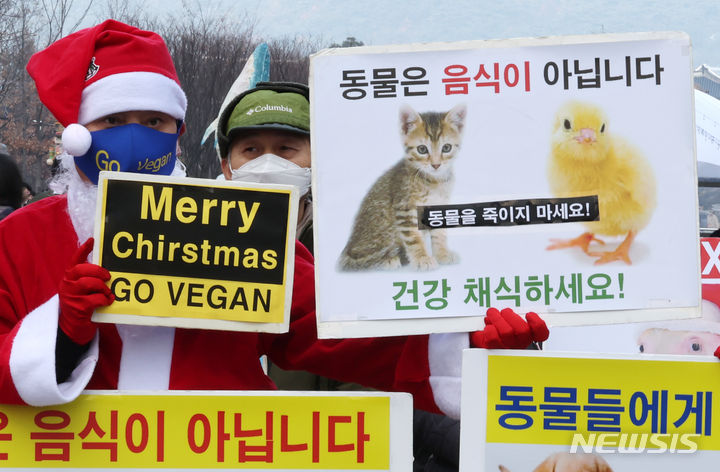 [서울=뉴시스] 김명원 기자 = 한국채식연합, 한국비건협회 회원들이 25일 서울 종로구 이순신동상 앞에서 인간과 동물 그리고 지구가 행복한 비건 크리스마스를 위한 기자회견을 하고 있다. 2023.12.25. kmx1105@newsis.com