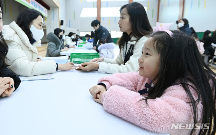 [수원=뉴시스] 김종택 기자 = 초등학교 예비소집일인 26일 경기도 수원시 영통구 영덕초등학교에서 입학을 앞둔 예비초등학생이 선생님과 대화를 나누고 있다. 2023.12.26. jtk@newsis.com