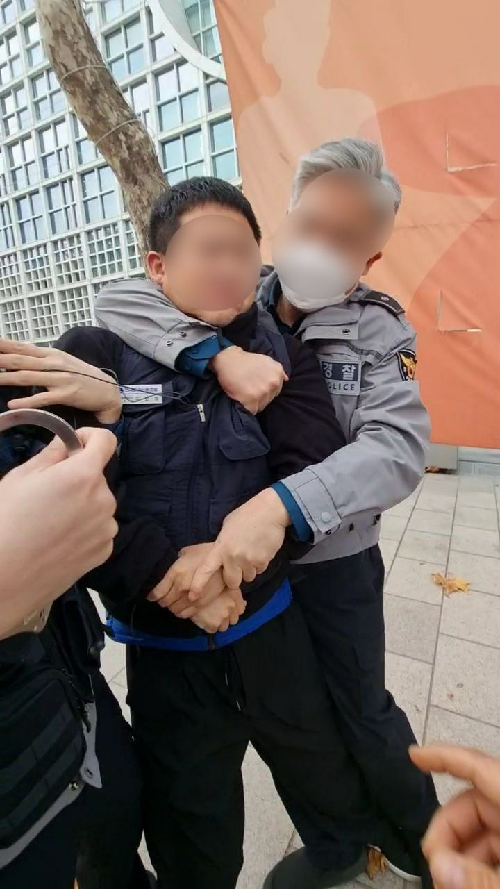 [서울=뉴시스] 지난해 11월24일 오전 8시30분께 현대자동차 국내영업본부가 있는 서울 강남구 대치동 오토웨이타워 앞에서 피켓 시위를 하던 김선영 금속노조 자동차판매연대 지회장이 공무집행 방해 등 혐의로 경찰에 현행범 체포되고 있다.(사진=금속노조 제공) 2023.12.27. photo@newsis.com *재판매 및 DB 금지