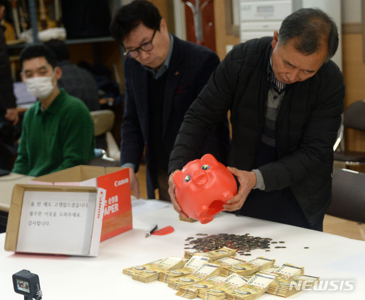 [전주=뉴시스] 김얼 기자 = 27일 전북 전주시 노송동 주민센터에서 주민센터 직원들이 '얼굴 없는 천사'가 전달한 성금을 정리하고 있다. 얼굴 없는 천사는 8006만 3980원의 성금과 "올 한 해도 고생 많으셨습니다. 불우한 이웃을 도와주세요. 감사합니다."라고 적힌 편지를 함께 보내왔다. 2023.12.27. pmkeul@nwsis.com