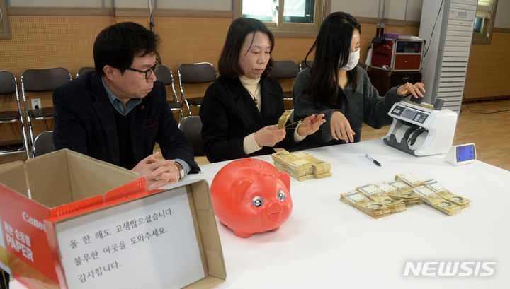 [전주=뉴시스] 김얼 기자 = 27일 전북 전주시 노송동 주민센터에서 주민센터 직원들이 '얼굴 없는 천사'가 전달한 성금을 정리하고 있다. 얼굴 없는 천사는 8006만 3980원의 성금과 "올 한 해도 고생 많으셨습니다. 불우한 이웃을 도와주세요. 감사합니다."라고 적힌 편지를 함께 보내왔다. 2023.12.27. pmkeul@nwsis.com