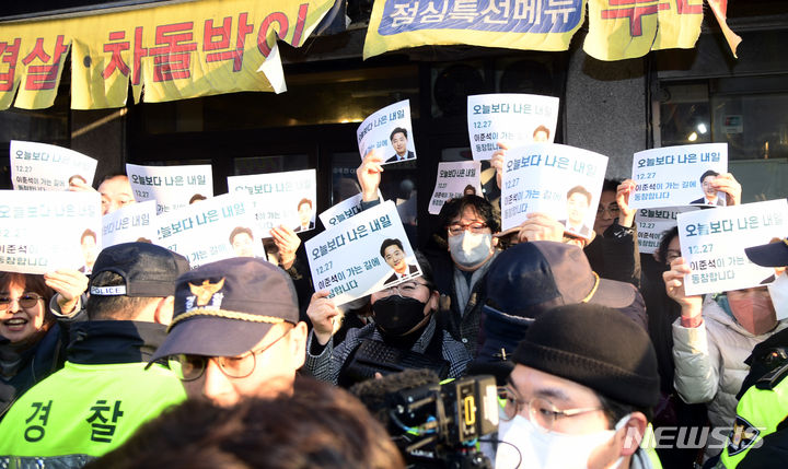 [서울=뉴시스] 권창회 기자 = 이준석 전 국민의힘 대표가 27일 오후 서울 노원구 상계동의 한 갈빗집에서 탈당 기자회견을 하는 가운데 지지자들이 '이준석이 가는 길에 동참합니다'라고 적힌 피켓을 들어보이고 있다.(공동취재) 2023.12.27. photo@newsis.com