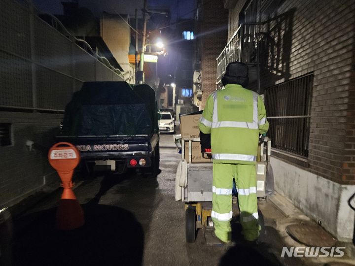 [서울=뉴시스] 이태성 기자 =환경미화원이 길가에 놓인 각종 폐기물을 수거하고 있다. 2023.12.28. victory@newsis.com *재판매 및 DB 금지