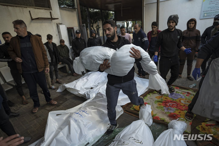 [라파( 가자지구)=AP/뉴시스] 가자지구 남부 라파 시내에서 12월 29일 이스라엘군 폭격으로 사망한 가족의 시신을 운반하는 팔레스타인 남성. 가자지구의 병원과 의료인에 대한 이스라엘군의 공격을 비난하는 국제적십자위원회(ICRC)의 성명이 9일 발표되었다. 2024. 01.10.