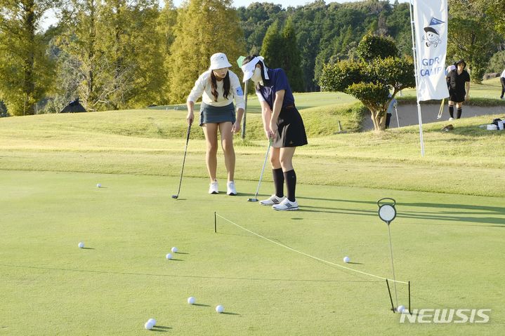 [서울=뉴시스] 일본 가고시마 사츠마GC에서 진행된 해외필드레슨 GDR캠프 참가자가 레슨프로에게 레슨을 받고 있다. (사진=골프존 제공) 2023.12.29. photo@newsis.com