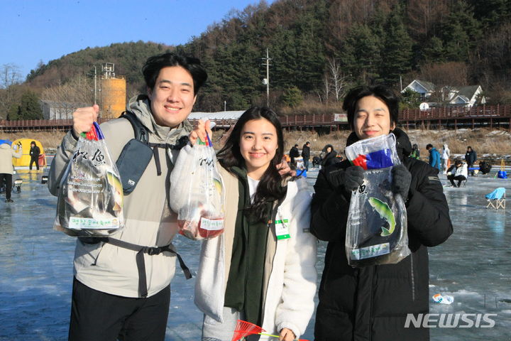 [평창=뉴시스] 김의석 기자 = 29일 오후 평창군 진부면 오대천 일원에서 열린 대한민국 대표 겨울축제 '평창송어축제'에서 참가자들이 잡은 송어를 들어보이고 있다. '평창송어축제'는 이달 29일부터 내년 1월 28일까지 한 달간 열린다. 2023.12.29. cw32784@newsis.com