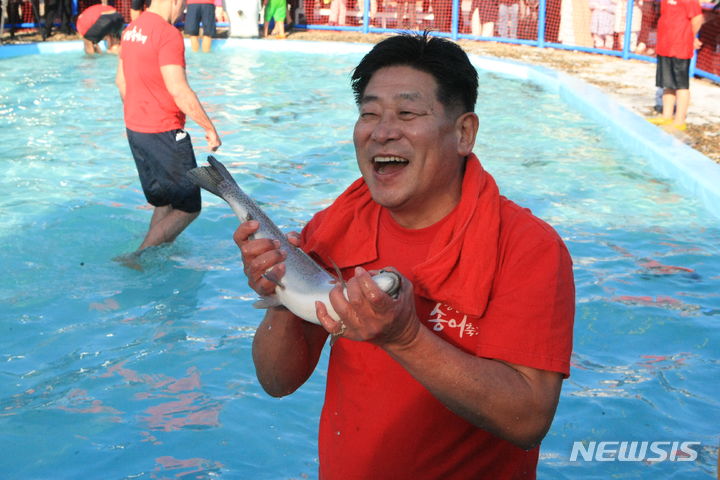 [평창=뉴시스] 김의석 기자 = 심현정 평창군의장이 29일 오후 평창군 진부면 오대천 일원에서 열린 대한민국 대표 겨울축제 '평창송어축제'에서 송어맨손잡기를 하고 있다. '평창송어축제'는 이달 29일부터 내년 1월 28일까지 한 달간 열린다. 2023.12.29. cw32784@newsis.com