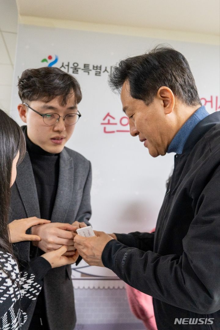 [서울=뉴시스]29일 실로암 시청각장애인 학습지원센터에서 정보화교육사업을 담당하는 조현상씨(시청각장애인)가 오세훈 서울시장이 건넨 점자 명함을 확인하고 있다.(제공=서울시)