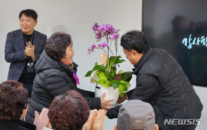 [영주=뉴시스] 김진호 기자 = 소백산영주스파리조트 보수공사 현황 주민설명회에서 김매화(여·70·영주시 휴천2동 통장)씨가 "워터파크를 조속히 개장해 지역경제 활성화에 기여해 달라"며 김병구 소백산영주스파리조트 전무에게 화분을 전달하고 있다. 2023.12.29&nbsp; kjh9326@newsis.com 