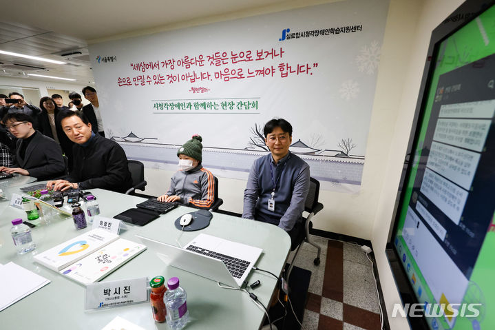 [서울=뉴시스] 황준선 기자 = 오세훈 서울시장이 29일 오전 서울 종로구 실로암시청각장애인학습지원센터에서 열린 시청각장애인과 함께 하는 현장 간담회에서 점자 키보드를 이용하는 시각장애인 참석자들에게 메신저를 통한 인사말을 하고 있다. 2023.12.29. hwang@newsis.com