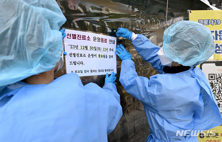 [광주=뉴시스] 김혜인 기자 = 코로나19 선별진료소 운영 종료를 앞둔 지난 29일 오후 광주 남구 선별진료소에서 의료진들이 운영 종료 안내 문구를 부착하고 있다. 2023.12.31. hyein0342@newsis.com