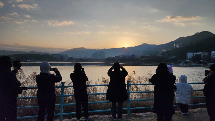 [대구=뉴시스] 이상제 기자 = 1일 오전 대구 수성구 수성못에서 2024년 갑진년(甲辰年) 첫 해가 떠오르자 해맞이객들이 기념사진을 촬영하고 있다. 2024.01.01. king@newsis.com *재판매 및 DB 금지